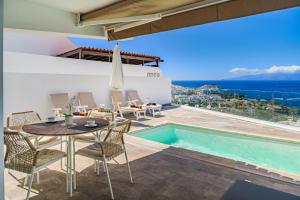 eine Terrasse mit Tisch und Stühlen und ein Swimmingpool in der Unterkunft Magnífico Bungalow con Vista Panorámica y Piscina Privada in Acantilado de los Gigantes