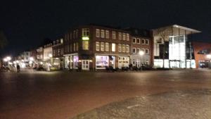 a group of buildings at night with lights at The Corner in Geleen