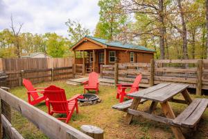 a picnic table and chairs in front of a cabin at Timber Ridge Retreat in Morton Grove