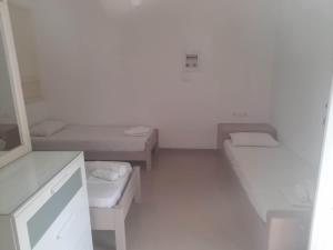 Una pequeña habitación con dos camas y un lavabo. en Studio A for 3 guests with kitchen, en Ios Chora