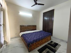 Un dormitorio con una cama y un ventilador de techo. en Savitry grees Home stay, en Zirakpur