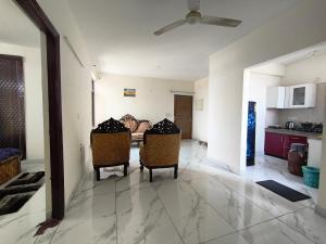Una sala de estar con dos sillas y una mesa. en Savitry grees Home stay, en Zirakpur