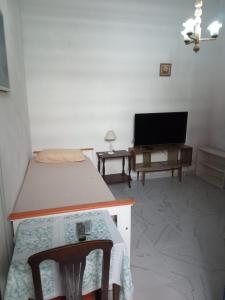 a bedroom with a bed and a tv and a table at Casa en Chacarita in Buenos Aires