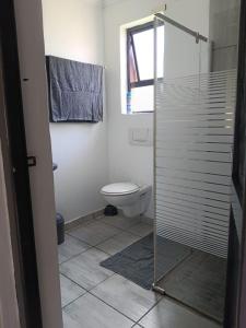 a bathroom with a toilet and a glass shower at Richards Bay Stay in Richards Bay