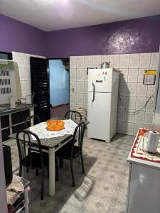 eine Küche mit einem Tisch und einem weißen Kühlschrank in der Unterkunft Casa da Dona Vera in Olímpia