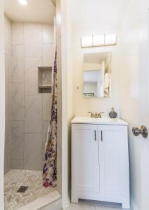a white bathroom with a shower and a sink at Full Triplex in Central Tucson EV charging in Tucson +40 photos