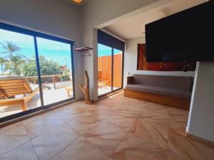 a living room with a flat screen tv and a large window at Espectacular Suite Frente a Playa Zicatela 1BDR in Brisas de Zicatela
