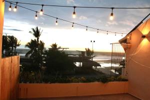 a view of the beach from a patio with lights at Espectacular Suite Frente a Playa Zicatela 1BDR in Brisas de Zicatela
