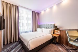 una habitación de hotel con una cama y una silla en Premier Inn Dresden City Centre, en Dresden