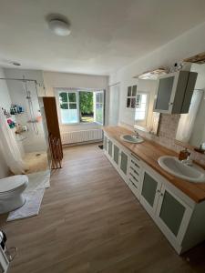 Un baño con dos lavabos y un inodoro. en Grande maison avec piscine 13 couchages proche Paris, en Rebais