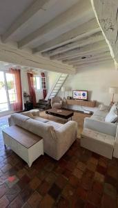 Una sala de estar con dos sofás y una mesa. en Grande maison avec piscine 13 couchages proche Paris, en Rebais