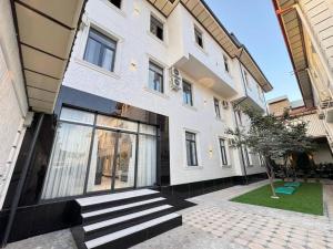 duży biały budynek ze schodami przed nim w obiekcie Marco Polo Hotel & SPA Tashkent w Taszkiencie
