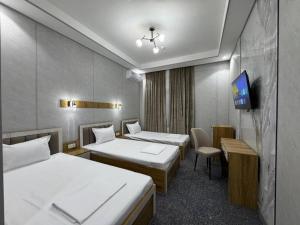 pokój hotelowy z dwoma łóżkami i telewizorem w obiekcie Marco Polo Hotel & SPA Tashkent w Taszkiencie