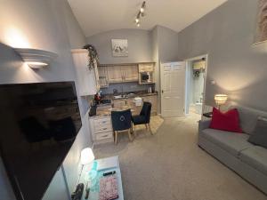 a small living room with a couch and a kitchen at Cosy County House apartment with free private parking Sleeps up to four guests in York