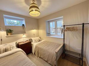 a bedroom with two beds and a chandelier at The Light Keepers Retreat in Cromer