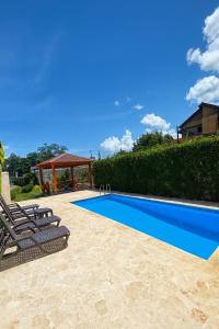 a swimming pool with two lounge chairs and a gazebo at 3 Bedroom Penthouse with private Rooftop Terrace in Sosúa