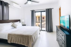 a bedroom with a bed and a flat screen tv at 3 Bedroom Penthouse with private Rooftop Terrace in Sosúa