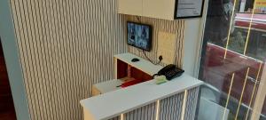 a bathroom with a sink and a phone on a counter at Sunlight Dormitory in Mumbai