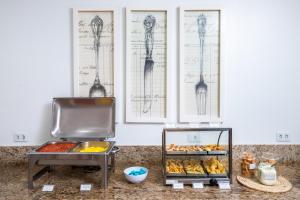 a buffet with pastries and drawings on the wall at Hotel Suárez São Leopoldo in São Leopoldo