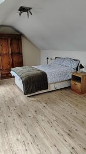a bedroom with a bed and a wooden floor at Arthur house in Whitehouse Lower