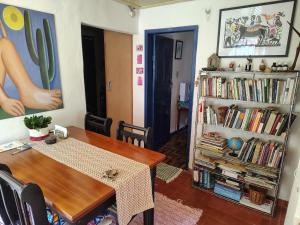 a dining room with a table and a book shelf at Casinha próxima a Praça Tiradentes in Ouro Preto