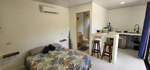 a living room with a couch and a kitchen at Casita Ola N en Caribe Sur in Talamanca