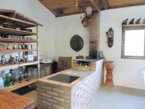 eine Küche mit einem Backsteinofen in einem Zimmer in der Unterkunft Pousada Viajantes do Tempo in Cunha