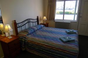 a bedroom with a bed with two towels on it at Parkhaven Motel in Goulburn