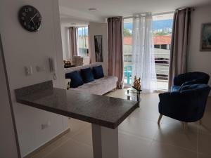 a kitchen and living room with a clock and a couch at malaquias in Ibagué