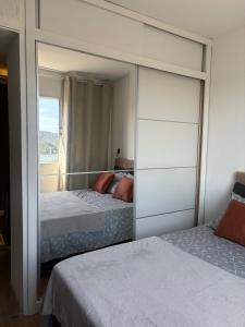 Giường trong phòng chung tại Kitnet Vista Mar em São Vicente - Charme e Conforto