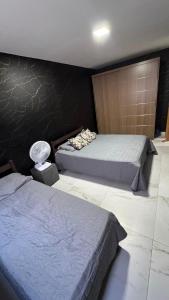 a bedroom with two beds and a wall at Casa Almar Carapibus in Conde