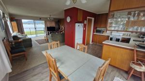 a kitchen with a table and chairs in a room at Tairua Harbourside Haven in Tairua