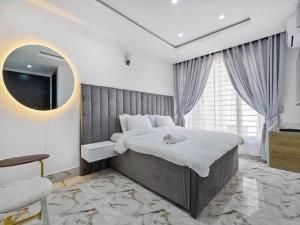 a bedroom with a large bed and a mirror at BASLEY HOTEL in Abuja
