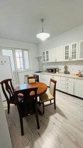 une cuisine avec une table et des chaises en bois dans l'établissement ЖК Асель, à Atyraū