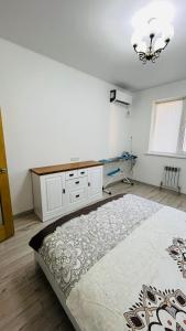 une chambre avec un lit et un bureau dans l'établissement ЖК Асель, à Atyraū