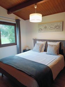 una camera da letto con un letto grande con una finestra di Le chalet forestier de Guerlande a Pézarches