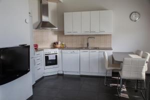 a kitchen with white cabinets and a table with chairs at Holiday Linnunlahti in Joensuu