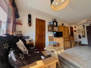 a living room with a couch and a tv at Appartement T3 rénové, lumineux, balcon et parking au centre du village de Samoëns - FR-1-624-73 in Samoëns