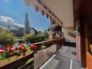 a balcony with a view of a garden with red flowers at Appartement T3 rénové, lumineux, balcon et parking au centre du village de Samoëns - FR-1-624-73 in Samoëns