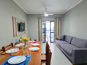 a living room with a table and a couch at Apt novo a poucos passos do mar em Meia Praia Itapema 2 quartos in Itapema