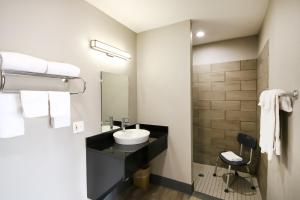 a bathroom with a sink and a mirror at Home 6 by Townhouse Topeka KS I 70 in Topeka