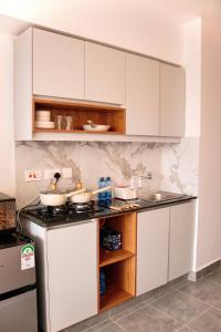a kitchen with white cabinets and a counter top at Eloura Homes Stanley Studio in Kiambu +5 photos