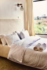 a bed with two towels on it with a window at Eloura Homes Stanley Studio in Kiambu