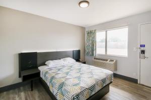 a bedroom with a bed and a window at Home 6 by Townhouse Topeka KS I 70 in Topeka