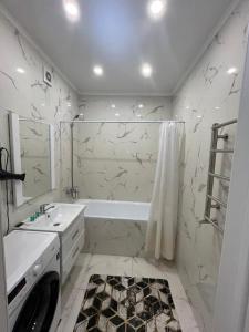 a bathroom with a tub and a sink and a shower at Комфортные апартаменты в ЖК Наурыз парк in Shymkent