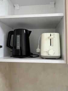 a coffee maker and a toaster sitting on a shelf at Astra Residence Ultracentral in Ploieşti