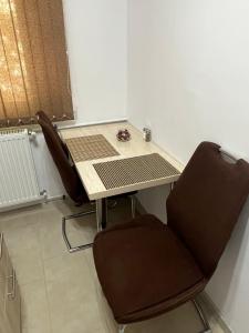 a table and two chairs in a room at Astra Residence Ultracentral in Ploieşti +8 photos