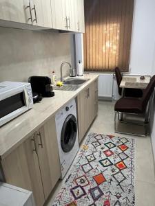 a kitchen with a sink and a washing machine at Astra Residence Ultracentral in Ploieşti