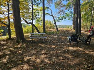 two benches and a picnic table in a park at The Hocking Hills Store Campsite #3 in Logan