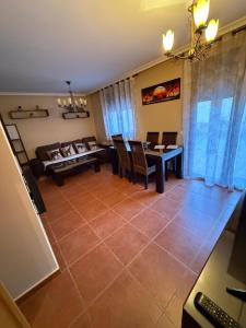 ein Wohnzimmer mit einer Couch und einem Tisch und Stühlen in der Unterkunft Cuencaloft Relax en familia con barbacoa in Chillarón de Cuenca